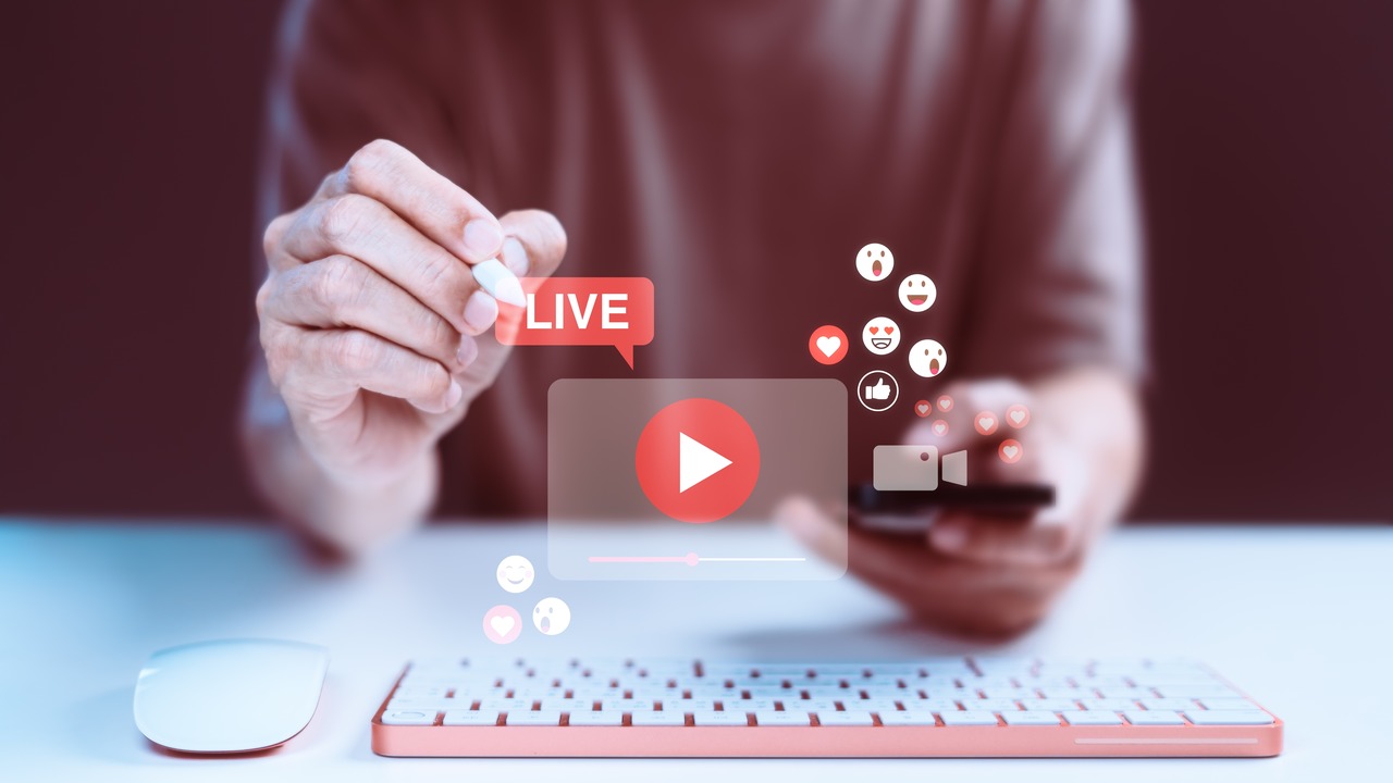 sosyal medya simgelerini içeren canlı video oynatıcıyla etkileşim kuran bir el